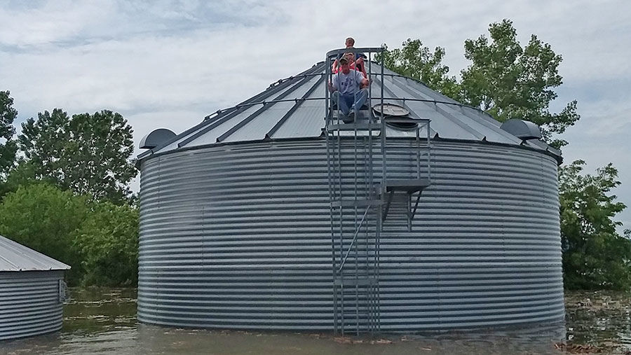 family atop one of their grain bins